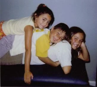 Three smiling kids on an adjusting table at Marion Family Chiropractic