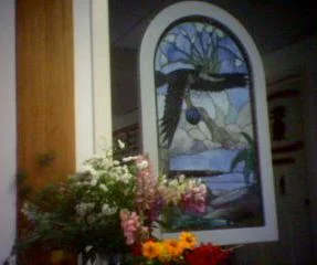 Stained glass window with an eagle and wildflowers in the office